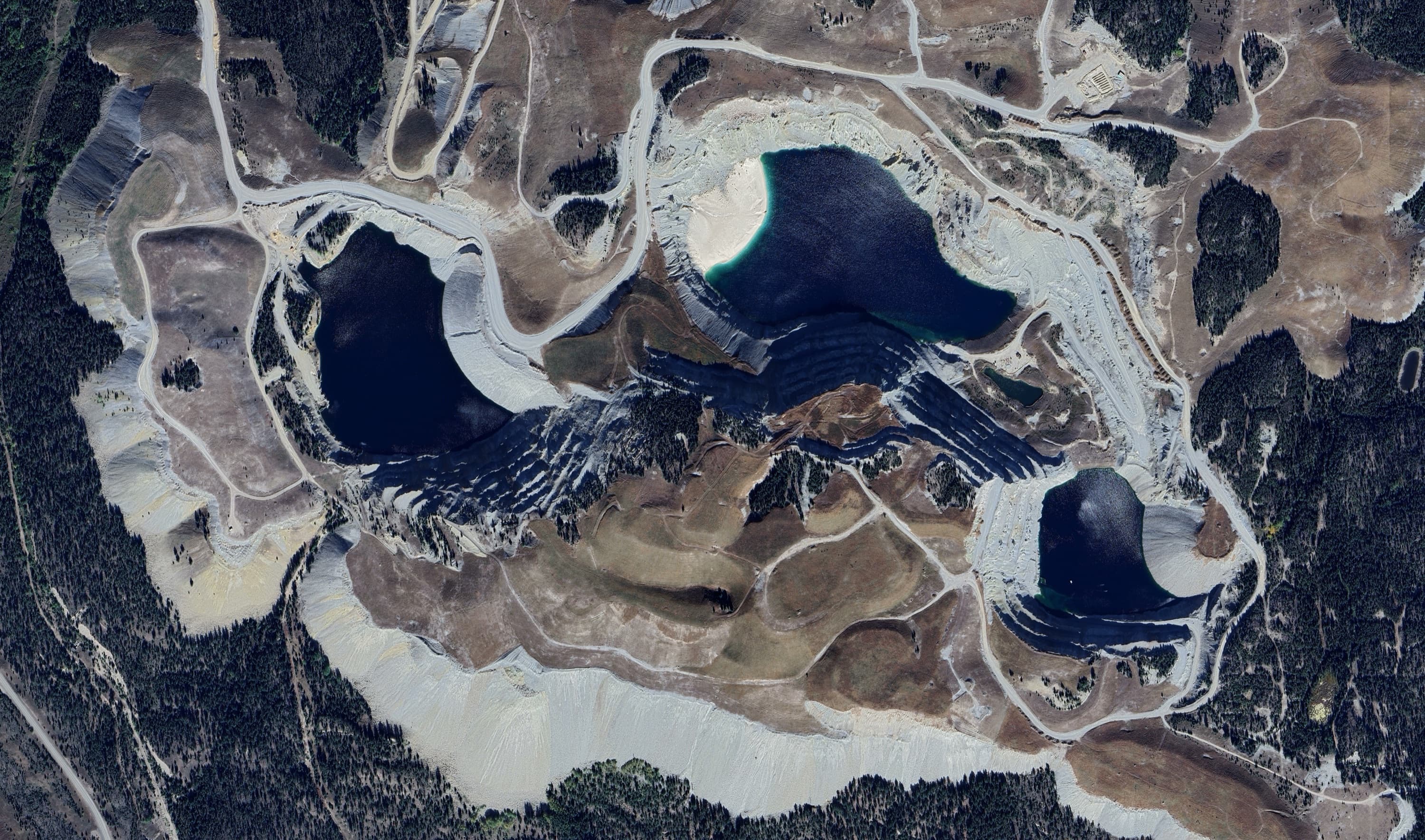 Satellite-view aerial of terraced industrial mining terrain